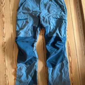 Norrøna friluftsbyxor  - Grymma friluftsbyxor från Norrøna. Byxorna har partier med strech över knän och bak. Använda men i väldigt fint skick. 🦋Katt finns i hemmet, därav något håriga. Rollas av innan de skickas. 