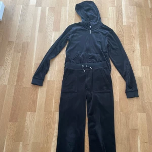 Svart velour set från Juicy Couture - Mysigt svart set från Juicy Couture i mjuk velour, med snygga detaljer. Byxor i strl xxs, man passar xs. Och tröja i strl 13 år och ganska långa armar.