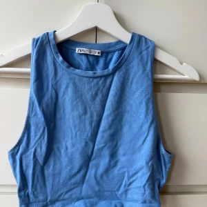 Blå croppad linnetopp från Zara - Snygg blå croppad linnetopp från Zara med rund halsringning och ärmlös design. 