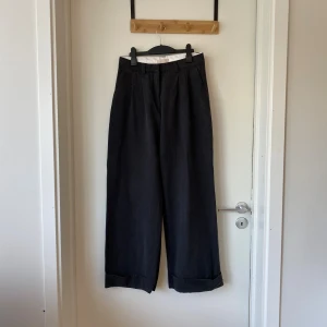 Vida, mörkgrå byxor  - Jättefina cotton/lyocell - byxor i kostymbyxmodell med uppvik. Älskar dem, men de är tyvärr för små i midjan för mig. Det står 38 i, men de passar någon med storlek 36.