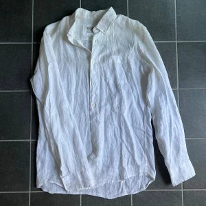 Vit linneskjorta från Mango - Säljer en stilren vit skjorta från Mango. Skjortan är tillverkad i svalt linne, har klassisk krage, bröstficka och knäppning framtill. Perfekt för dig som gillar en clean och fräsch look.