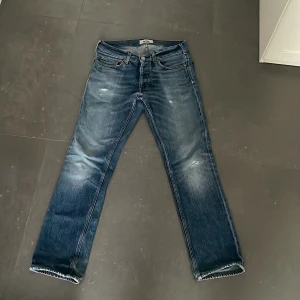 Blå raka jeans från Acne Studios - Säljer ett par klassiska blå jeans från Acne Studios med raka ben och snyggt slitna detaljer. normal passform. Perfekta för dig som gillar en tidlös och avslappnad look.