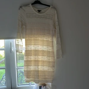 Vit spetsklänning med trekvartsärm - Säljer en söt vit spetsklänning med trekvartsärmar och rund hals