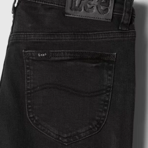 Svarta bootcut jeans från Lee - Snygga svarta jeans från Lee i modellen Jessica. Jeansen har klassisk femficksdesign, bootcut-ben och är tillverkade i stretchig bomullsdenim. Perfekta för dig som gillar en tidlös look med lite utsvängda ben.