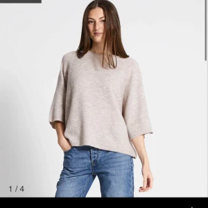 Beige stickad tröja med vida ärmar - Supermjuk och oversized stickad tröja i beige med breda trekvartsärmar och rund hals. Perfekt för lager-på-lager och chill vibes. Lätt att styla med jeans eller kjol för en avslappnad look.