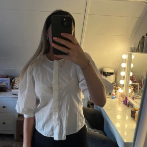 Vit skjorta med puffärm - Säljer en vit skjorta med puffiga trekvartsärmar och dold knappslå framtill. 