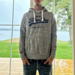Superdry Hoodie - Grå Superdry hoodie i mycket bra skick | Storlek: S | Jag är 182cm och väger 65kg📏| Vid frågor eller diskussion om pris är det bara att skriva ✍🏼 | Frakt inom 48h📦