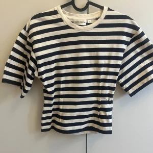 Randig t-shirt från carin wester - Snygg figursydd  t-shirt med marinblå och vita ränder från carin wester. Använd några få gånger, fint skick. 