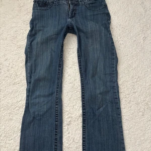Lee bootcut jeans med broderade fickor - Snygga blå bootcut jeans från Lee. Jeansen har låg midja och broderade bakfickor med mörkblå mönster. 💕