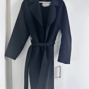 Svart kappa från Inwear - Svart kappa från Inwear. Väl använd, säljs i befintligt skick. Luktar parfym och hund har funnits i hemmet, därmed säljs den i befintligt skick till billigt pris. Passar mig som är en 38-40, M/L. Eu38 dam modell. Köpt på Åhléns City i Göteborg 
