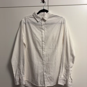 Vit skjorta från 157  - Klassisk vit linne skjorta från 157 med krage och knäppning framtill. Perfekt för en clean och stilren look.