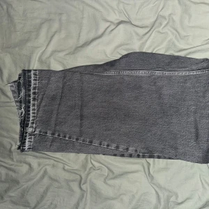 Flared jeans från Zara - Snygga grå jeans med raka ben och rå, fransad kant nertill. Jeansen har klassisk femficksdesign och en tvättad look som ger en cool vintagekänsla. Perfekta för dig som gillar avslappnad stil med edge.  Jeansen passar även alla som har längd 32,33 och 34 på jeans.