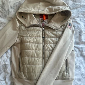 Beige cardigan från Parajumpers - Snygg beige cardigan från Parajumpers med huva och dragkedja framtill. Nypris är runt 2.500kr. Har inga synliga defekter! Men skriv om du undrar något💕