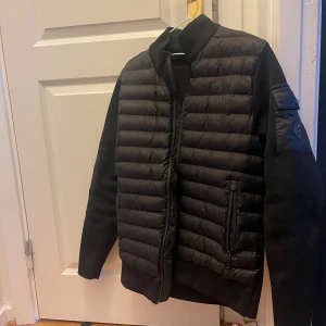  Moncler cardigan  - Har inte använt den så mycket. Säljer en svart pufferjacka från Moncler med quiltad framsida och släta ärmar. Jackan har Moncler-logga på ärmen, dragkedjor på fickorna och en cool serietidningsetikett på insidan. Perfekt för dig som vill ha en stilren jacka med exklusiva detaljer.