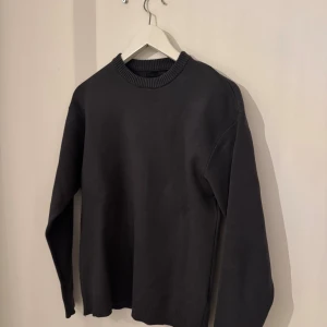 Svart stickad tröja från Zara - En stilren svart stickad tröja från Zara i storlek S. Tröjan har rund halsringning med ribbade detaljer och långa ärmar. Perfekt för lager-på-lager och enkel att matcha med olika outfits.