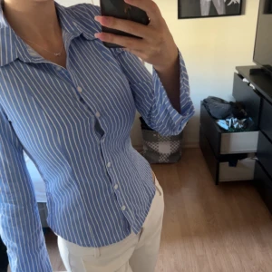 Blåvit randig skjorta med knappar - Hej! Säljer denna otroligt snygga skjorta då den inte passar mig helt riktigt . Skjortan är från Bershka i storlek S . 