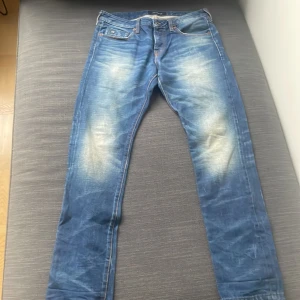Blå  jeans från Scotch & Soda 31/32 - Snygga blå jeans från Scotch & Soda, modell Ralston. Jeansen har en klassisk femficksdesign, tydliga slitningar och ljusa partier framtill och baktill. Perfekt nu i höst/vinter. Hör av er vid frågor😁