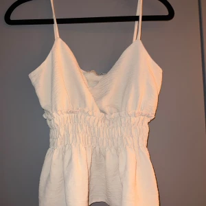 Beige linnetopp  - Supersöt beige linnetopp med smala axelband och omlott-v-ringning i storlek S