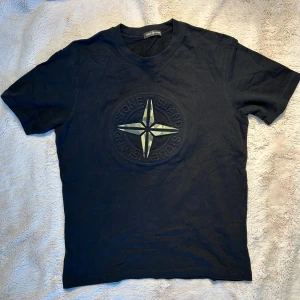 Svart Stone Island t-shirt med logga - Svart t-shirt från Stone Island med stor broderad logga på bröstet.                                                                     Storlek M                                                                         ✅skriv för frågor, mått eller mer bilder ✅