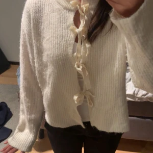 Vit stickad kofta med knytband - Superfin vit stickad kofta med ribbad struktur och rosettband framtill. En mysig kofta som kommer vara perfekt när det blir kyligare ute! Den är från Gina Young i storlek 158/164 och passar mig som vanligtvis har xs/s 💕💕