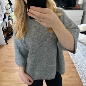 Grå stickad tröja med trekvartsärm - Mysig grå stickad tröja med trekvartsärmar och högre ribbad hals. Tröjan har en loose passform och är perfekt för lager-på-lager. Enkel och stilren design som funkar till allt. Superbekväm och köpt från Lager 157 🫶🏻