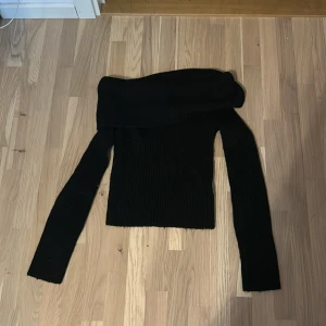 Svart offshoulder stickad tröja H&M - Säljer en svart stickad tröja från H&M i storlek XS. Tröjan har offshoulder-modell och är ribbstickad med långa ärmar. Perfekt för dig som gillar en stilren och trendig look med en twist.