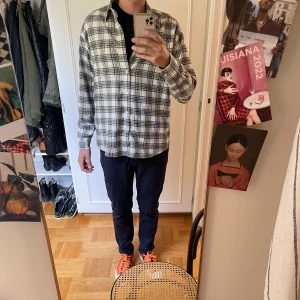 Flanellskjorta NN07 - Riktigt snygg rutig skjorta från NN07 i svart och vitt. Skjortan har klassisk krage, bröstficka och knäppning framtill. Tillverkad i mjuk bomull och har en relaxed passform med långa ärmar. Perfekt för en chill och stilren look. Storlek M och i mycket fint skick! 649kr, hör av er om ni har några frågor eller funderingar!