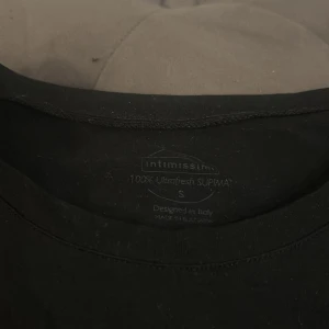 Svart t-shirt från Intimissimi - En stilren svart t-shirt från Intimissimi i 100% Ultrafresh Supima bomull. Modellen är klassisk med rund hals och korta ärmar, perfekt för en clean och enkel look. Superskön och mjuk kvalitet som känns lyxig mot huden.