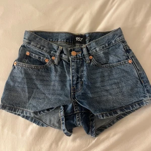 Lågmidjade Blå jeansshorts från 157 - Endast använda en gång lågmidjade Snygga blå jeansshorts från 157 med klassisk femficksdesign, låg midja och slitstarka sömmar. Shortsen har knapp och dragkedja framtill, bälteshällor och bakfickor. Perfekta för sommarens alla äventyr och har en loose passform.
