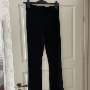 Svarta mjukisbyxor med bootcut - Svarta mjukisbyxor med bootcut och hög midja. Byxorna är i ett mjukt och stretchigt material som sitter skönt på kroppen. Perfekta för en chill och avslappnad stil.