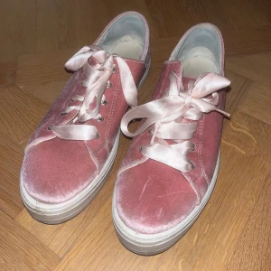 Rosa sneakers i sammet med sidenband - Säljer ett par snygga rosa sneakers i sammet med breda sidenband som snörning. Haft de i ca ett år så dem är som nya då jag bara har använt de ett fåtal gånger. 