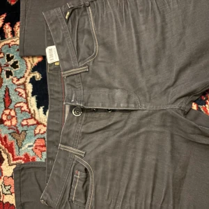 Jack & Jones Clark One jeans, grå - Snygga grå jeans från Jack & Jones, modell Clark One. Klassisk femficksdesign med kontrastsömmar och diskret logga bak. Jeansen har rak passform och är tillverkade i ett mjukt bomullsmaterial med en cool tvättad look. Perfekta för en avslappnad stil.