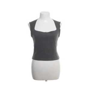 Mörkgrå ärmlös topp från Zara - Snygg mörkgrå ärmlös topp från Zara med fyrkantig urringning. Toppen är croppad och har en enkel, stilren design som passar perfekt till jeans eller kjol. Tillverkad i mjukt material som känns skönt mot huden.