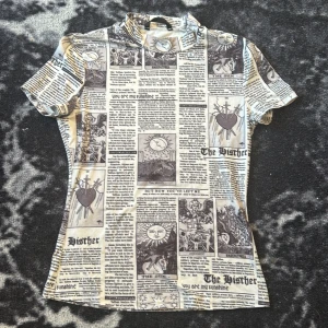  En kroppad topp med hög hals och tidning mönster -  En snygg kroppad topp med hög hals och tidning mönster perfekt för en uppklädd luck med en t-shirt 