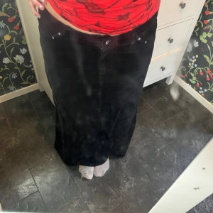 Svart manchesterkjol från Ze-Ze Concept - Säljer en svart långkjol i manchester från Ze-Ze Concept. Kjolen har klassisk femficksdesign, hällor för bälte och stängs med knapp och dragkedja framtill. Snygg och tidlös modell som är lätt att matcha med olika stilar.