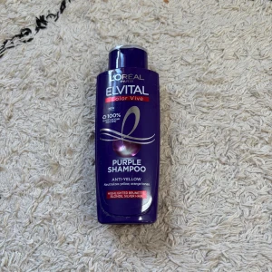 L'Oréal Elvital Purple Shampoo 200ml - Lila schampoflaska från L'Oréal Elvital Color Vive, Purple Shampoo. Speciellt framtagen för att neutralisera gula och orange toner i blont, slingat, brunt eller silverfärgat hår. Flaskan rymmer 200 ml och är tillverkad av återvunnen plast.