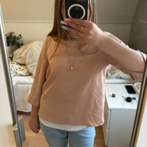 Beige/rosa blus med broderad halsringning💕 - Säljer en beige/rosa blus från Vero Moda med trekvartsärm och snyggt broderad halsringning i guld och svart! Materialet är svalkande och inte så tjockt. En pärla saknas men utöver det inga defekter, skriv för frågor❣️❣️