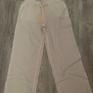 Vita linnebyxor från Gina Tricot - Snygga och luftiga vita linnebyxor från Gina Tricot med raka ben. Byxorna har fickor både fram och bak och är perfekta för en chill och avslappnad stil. Materialet är en skön linneblandning som känns fräscht och svalt. Endast testade, lappen är kvar. 