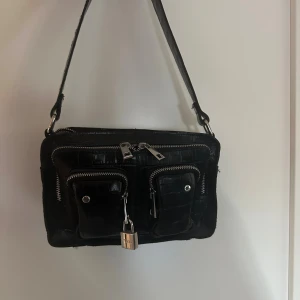 Nunno väska - Nunno väska i modellen ”Ellie Texas black”. Använd fåtal gånger, är som ny.   Nypris 1800 kr