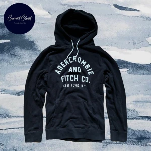 Svart hoodie Abercrombie & Fitch M - Svart hoodie från Abercrombie & Fitch med vit broderad logga på bröstet och klassisk känguruficka | Size M men är stor i storleken
