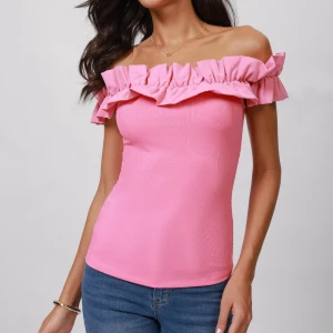 Rosa offshoulder topp med volang - Snygg rosa offshoulder topp med bred volang runt axlarna. Toppen är figurnära och har en ärmlös design som ger en trendig och feminin look. Perfekt att matcha med jeans eller kjol för en cool stil.