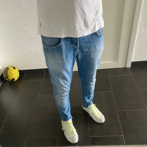 Dondup George - Säljer ett par ljusblå skinny fit jeans från dondup. Jeansen har klassisk femficksdesign, snygga slitningar och kontrastsömmar. Modellen är smal och sitter tajt längs benen, perfekt för en modern och avslappnad look.