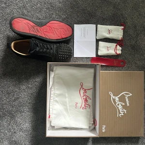 Svarta sneakers från Christian Louboutin - Säljer mina Christian louboutins, dem har lågra små defekter men dem är ändå i fint skick och går såklart och tvätta mer, skriv vid frågor kan sänka priset vid snabb affär, skorna kommer med extra nitar,skosnöre,box och skohorn!!!
