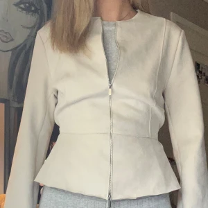 Beige jacka i mockaimitation  - Superfin tunn och beige  jacka i mockaimitation. dragkedja som kan öppnas både nere och uppe. Ger massor möjligheter att bära den på olika sätt🥰knyte där bak som ger en figursydd modell!! 
