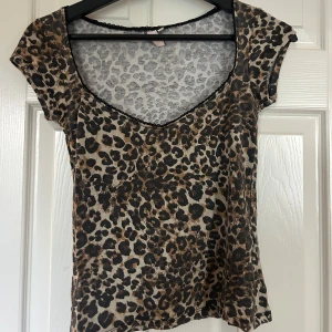 Leopardmönstrad topp från Nelly - Säljer en snygg leopardmönstrad topp från Nelly i storlek S. Toppen har korta ärmar, v-ringning med svart spetskant och är gjord i ett tunt, stretchigt material. Super fin💕