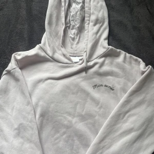 Ljusrosa hoodie från Gina Tricot🤍 - Ljusgrå hoodie från Gina Tricot med trycket 'Mon amie' på bröstet och ett hjärta med pil på ryggen. Tröjan har huva med snörning och är tillverkad i mjuk bomullsmix. Perfekt för chill dagar och snygg att matcha med jeans. Som ni ser så syns inte snöret på den vänstra sidan, så det får köparen lösa. Annars är den i jättebra skick🫶🏻