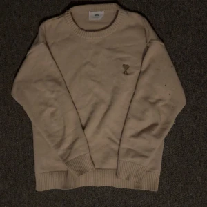 Beige tröja från Ami - Snygg beige stickad tröja från Ami Paris. Perfekt för dig som gillar stilrena och mjuka plagg med lite lyxig känsla. Jag har haft den ett tag men den är sparsamt använd så den är i riktigt bra skick.