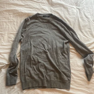 Grå merinoulltröja från Dressmann - Snygg grå tröja från Dressmann i mjuk merinoull. Klassisk rund hals och långärmad modell, säljer då den blivit för liten för mig. Perfekt för dig som gillar stilrena och bekväma plagg. Passar dig som vill ha en enkel men schysst look. Pris kan diskuteras vid snabb affär! 