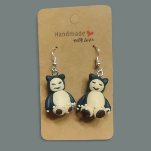 Snorlax örhängen - Unika handgjorda örhängen med Snorlax-figurer i mörkblått och beige. Perfekt för dig som älskar Pokémon och vill ha något personligt och lekfullt i din stil.
