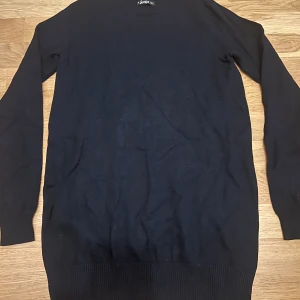 Svart långärmad tröja från Crocker - En svart långärmad tröja från Crocker i storlek XXS. Tröjan har rund hals och är tillverkad i en mjuk blandning av viskos och nylon. Ribbad kant vid hals och nederdel.